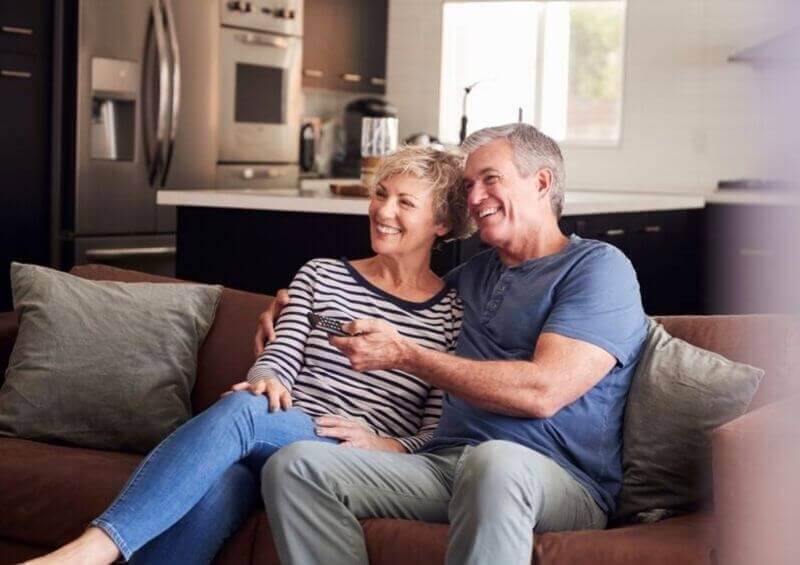 Couple sat on the sofa watching tv