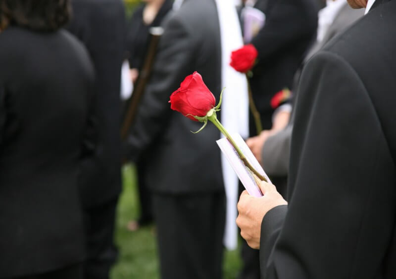 Person holding flower at funeral